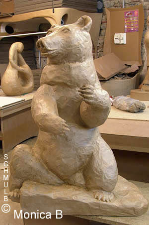 Sculpture en papier mâché d'un ours sur socle en carton.